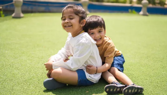 Two siblings smiling and hugging each other