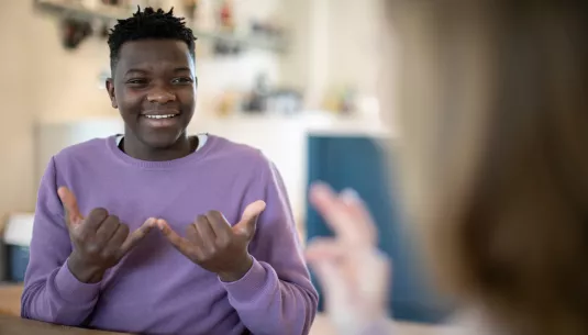 A teenage boy using sign language