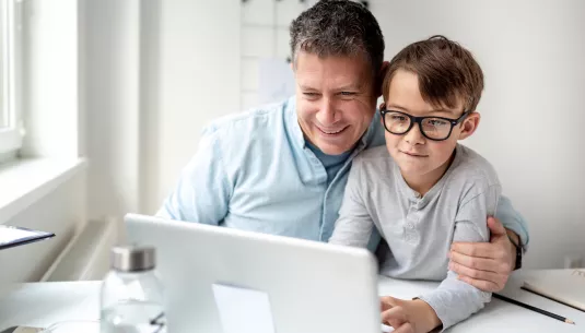 A father and son looking at laptop