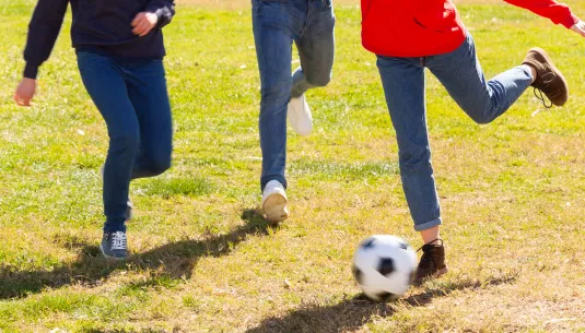 Three teenagers playing football