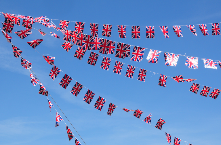 Union flag bunting joined together in front of a bright blue sky