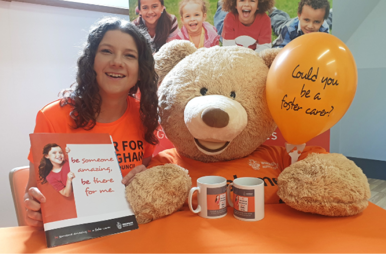Foster carer Sian holding promotional materials for foster care fortnight