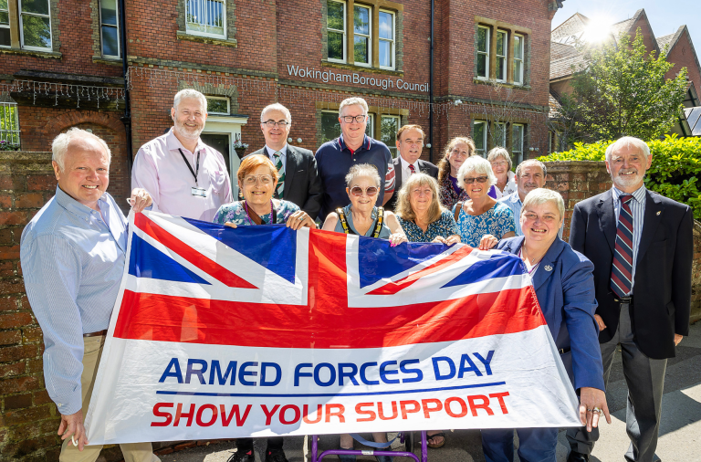 Councillros from all political parties hold the Armed Forces Day flag