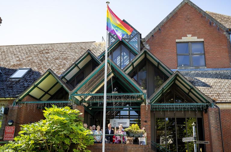 Cllr Beth Rowland raises the Pride flag on the council's Shute End office in Wokingham