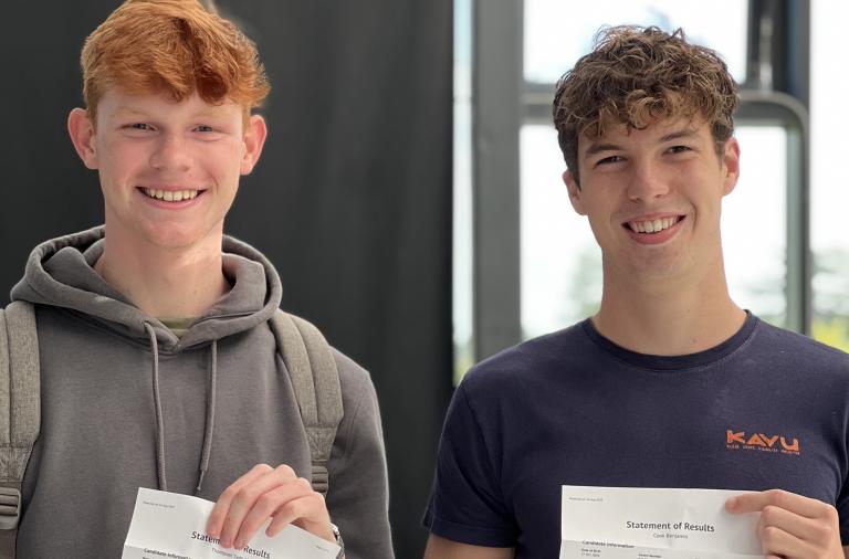 Two male students from St Crispins hold up their exam results