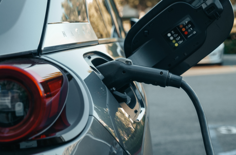 A close up of an electric car being charged