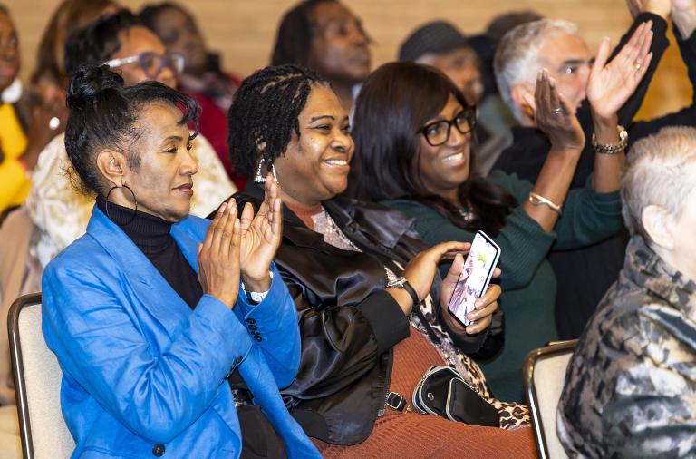 The audience claps along with joyous expressions to celebrate the performance at the Black History Month musical celebration event