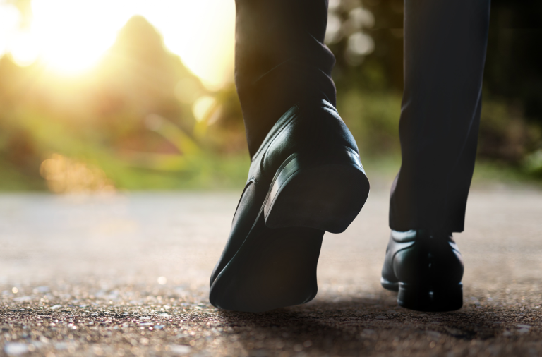 Stock images showing close-up of feet wearing business shoes walking on a path outside