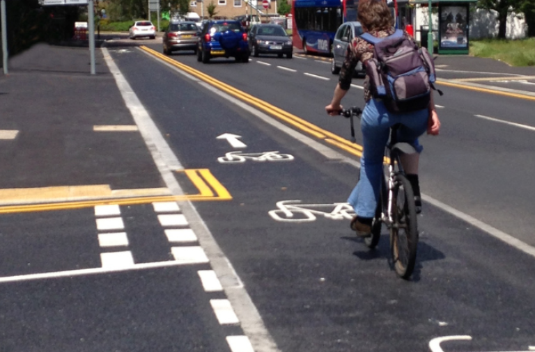 A photograph of a raised cycle track crossing in front of a side junction, with cyclists given priority over emerging traffic