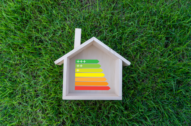 energy perfomance rating scale chart shown in a small toy house on an astro-turf background