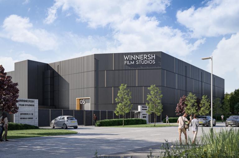 Artists impression of a modern film studio building with angled corners and sleek dark grey cladding