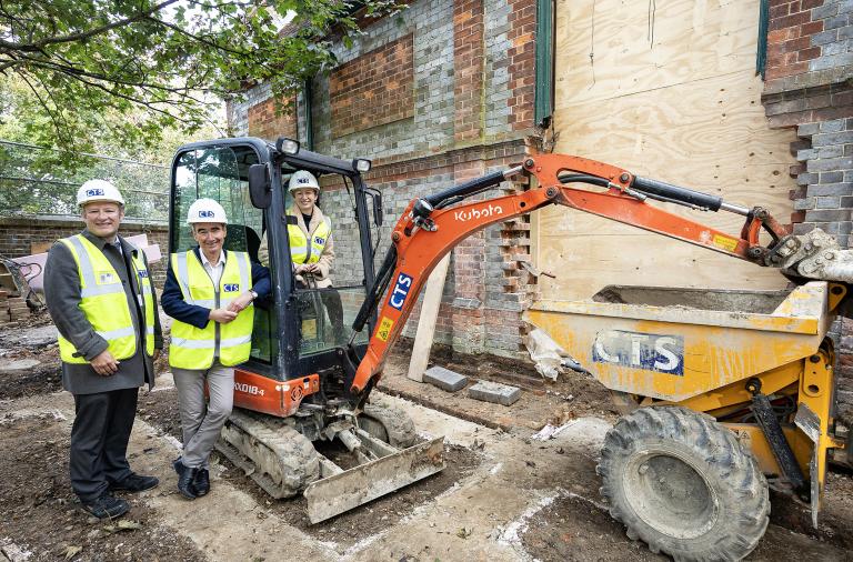 Cllr Sarah Kerr, Cllr Stephen Conway and Mr Weston from CTS stood next to a digger looking at the foundations for the new extension at the new Twyford Library