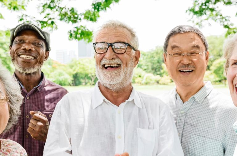 Group of male and female adults outside under a tree