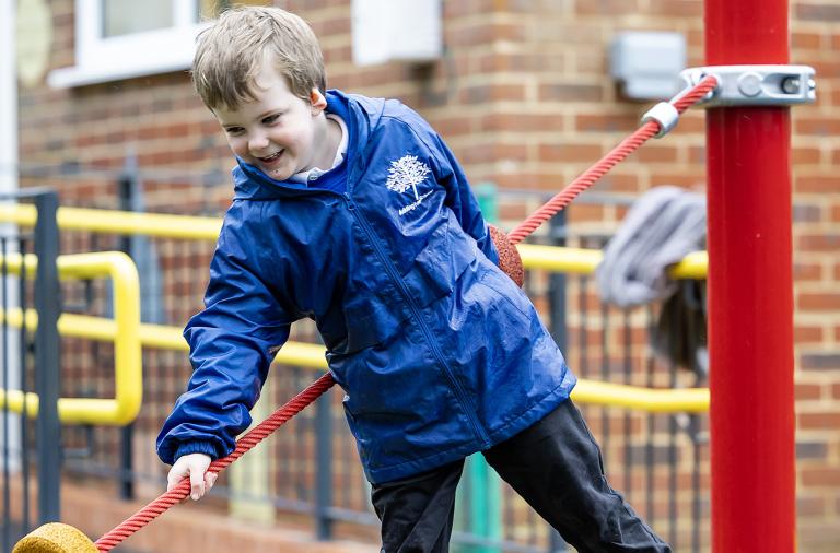 A pupil from Addington Early Years Centre playing outside on textured playground