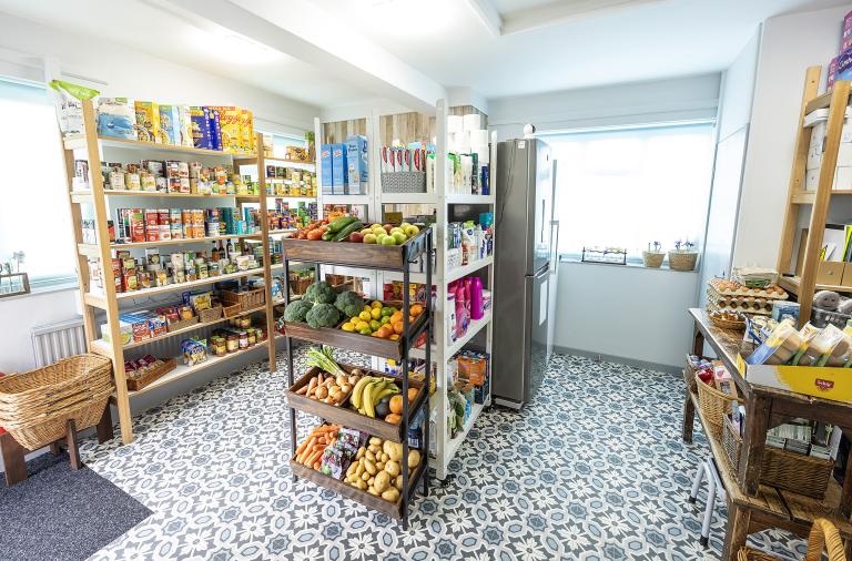 Shelving units showing an array of food and other goods at the Roots Community Pantry