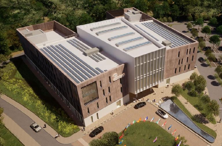 A computer generated aerial image of a new four storey building surrounded by woodland, with a small car park