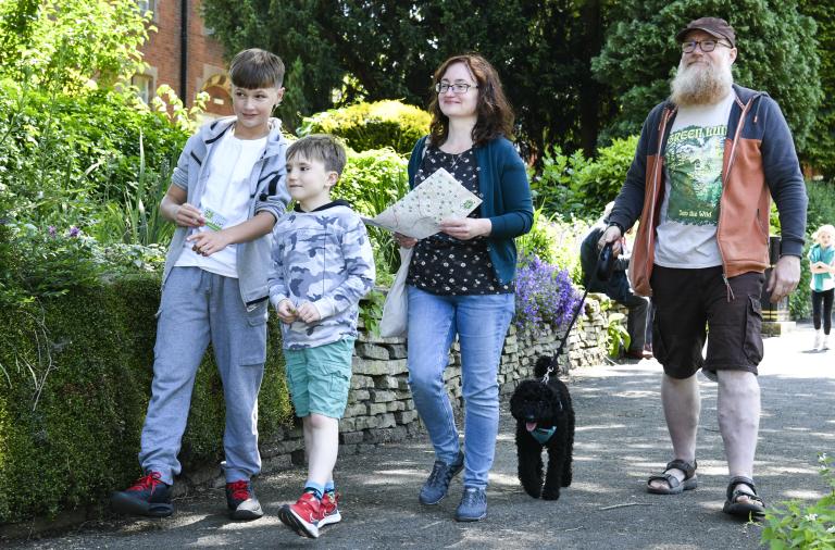 A family out walking along the pavement together on a sunny day