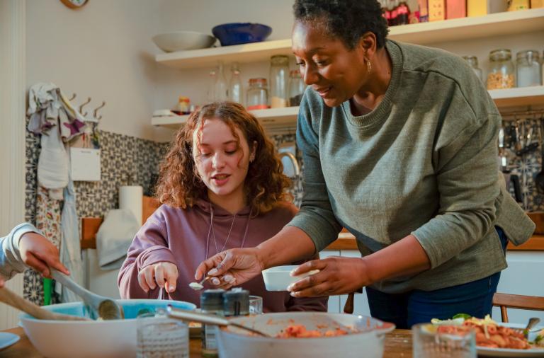 A foster carer and looked after youth preparing food together