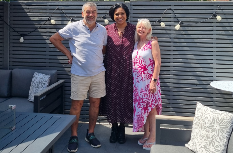 Minister Daby stands outside with Sue and Les