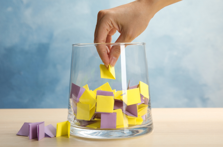 Hand reaching into a bowl to pick a winning ticket