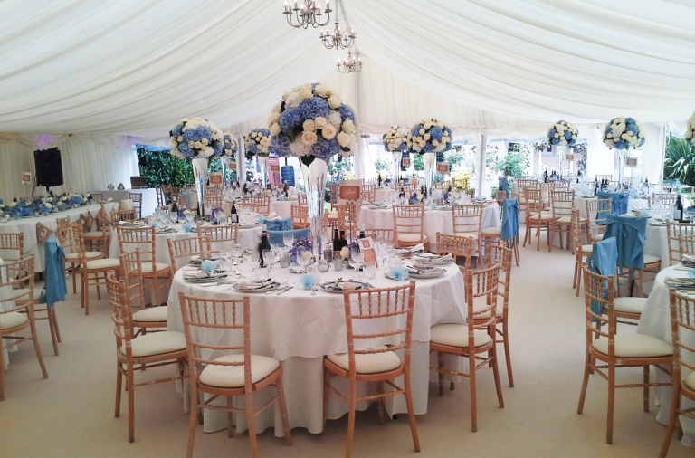 Photo of an indoor wedding, chairs in a marquee