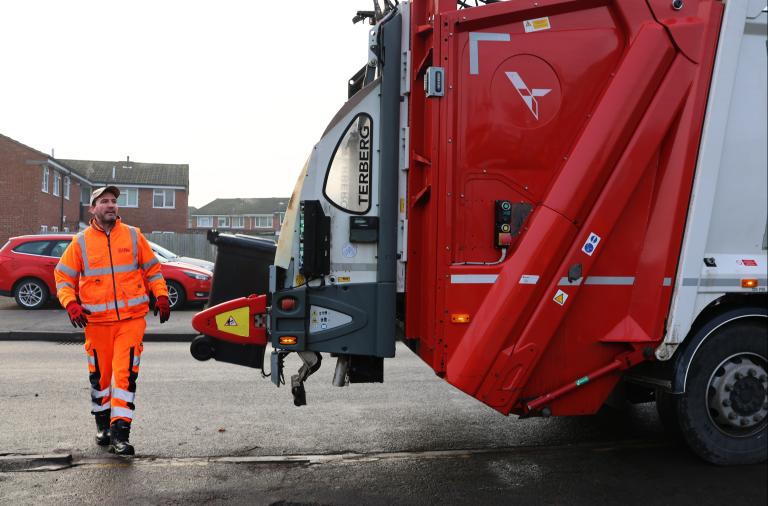 Biffa employee loading a wheeled bin onto a lorry