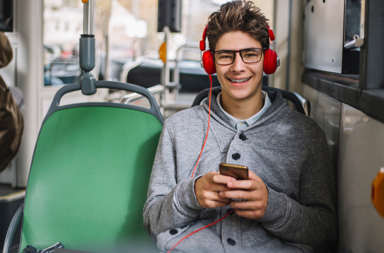 A teenage boy on the bus listening to music