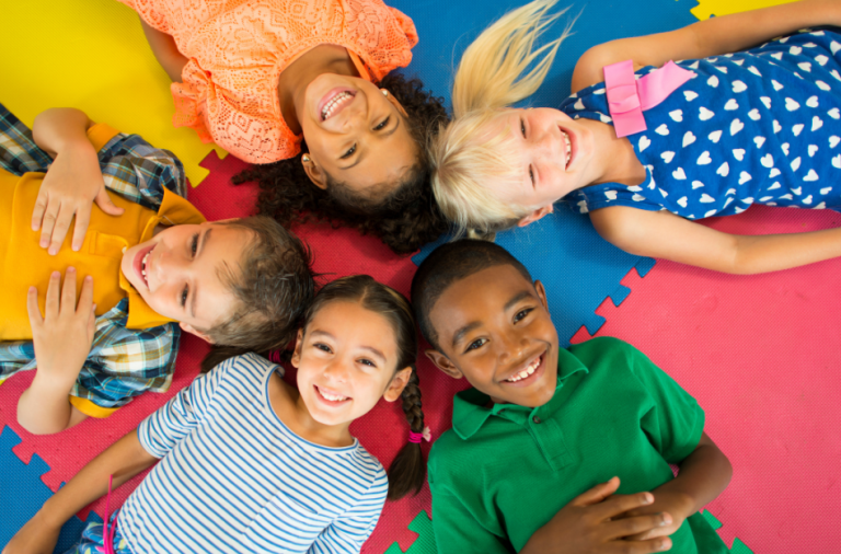 Children laying on a play mat, facing upwards