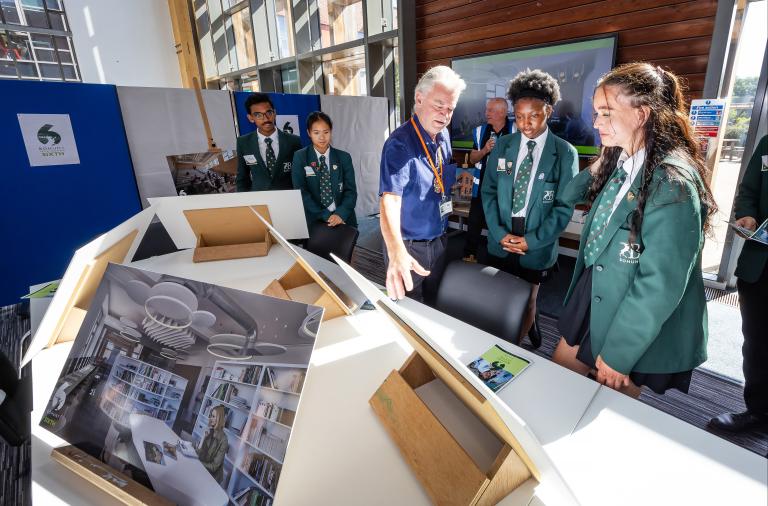 Deputy Mayor Cllr Rob Comber looking at illustrations of Bohunt Wokingham Sixth with school children