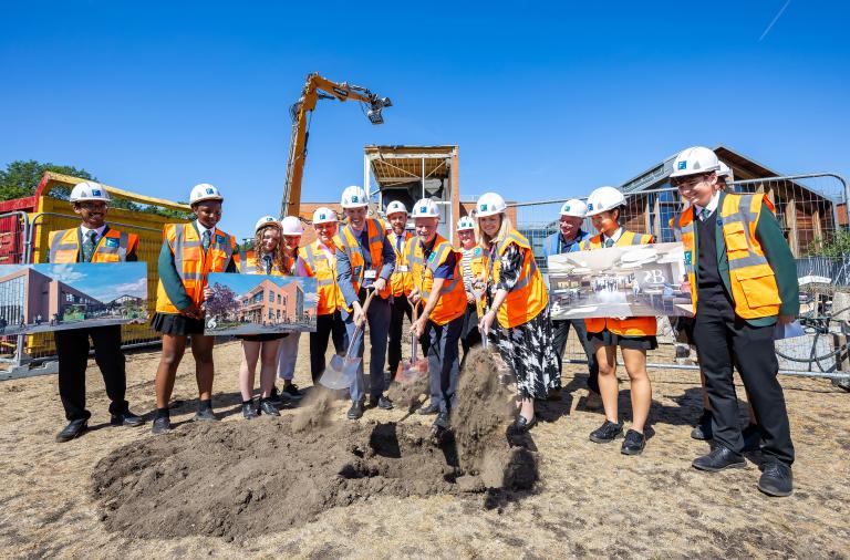 Deputy Borough Mayor Cllr Rob Comber, headteacher Jen Comber, executive headteacher Mark Marande break the ground with shovels. Also in attendance are representatives from the council and the project’s contractors Francis Construction and school children.