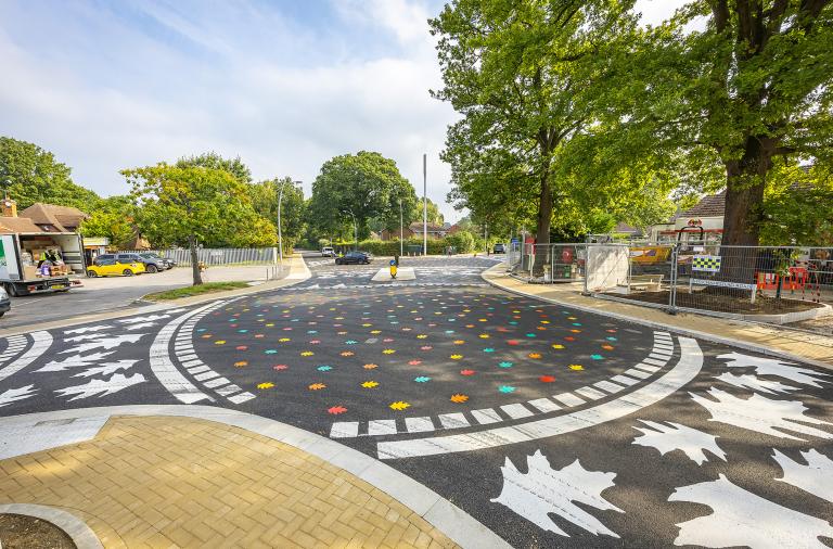 View of the new junction at California Crossroads with new level pavements and a shared surface with colourful leaf patterns on it