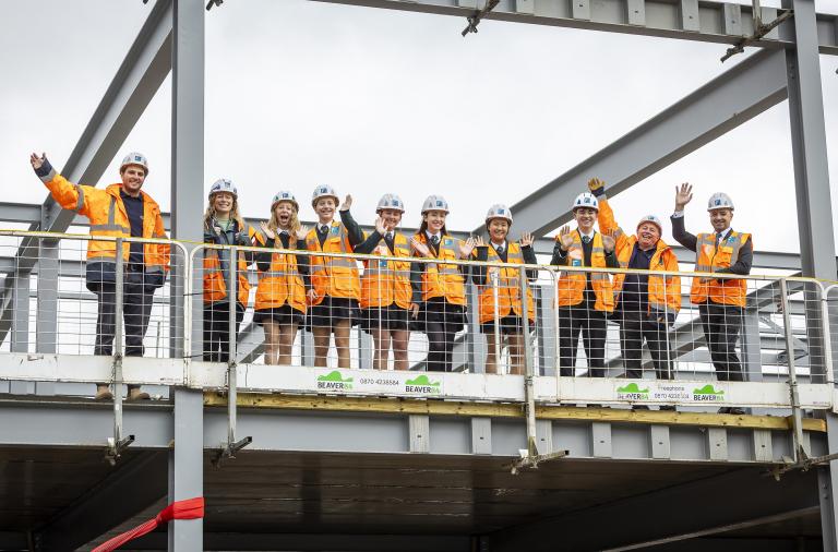 Bohunt School sixth form ambassadors, the headteacher and workers from Francis Construction smiling at the top of the building