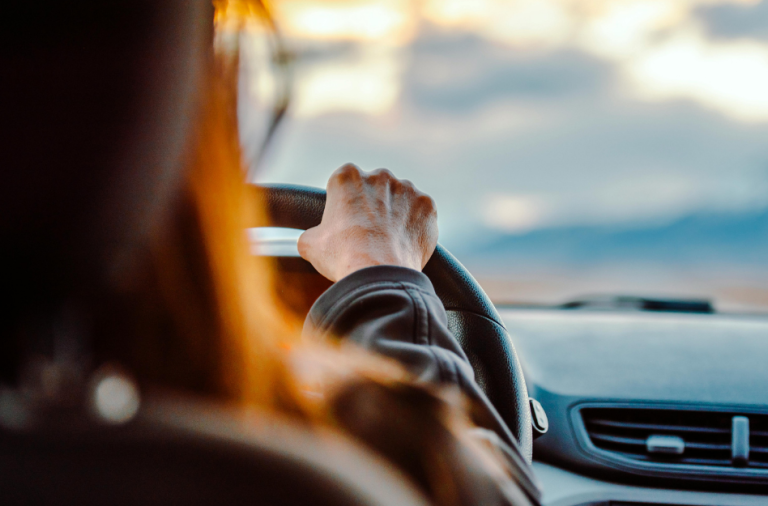 General view of someone anonymous behind the wheel of a car