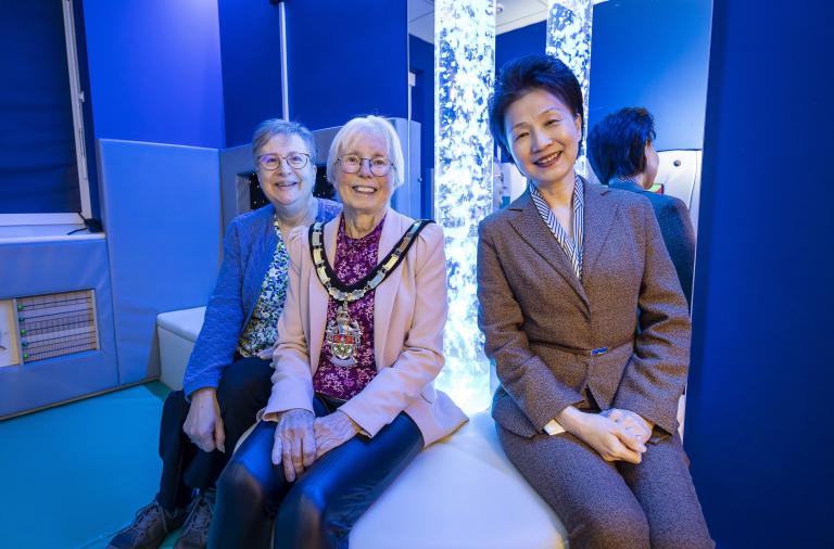Borough Mayor Cllr Carol Jewell with Cllr Prue Bray and Headteacher Li-Juan Ellerton in the new sensory room. A light up, sensory lamp is behind them