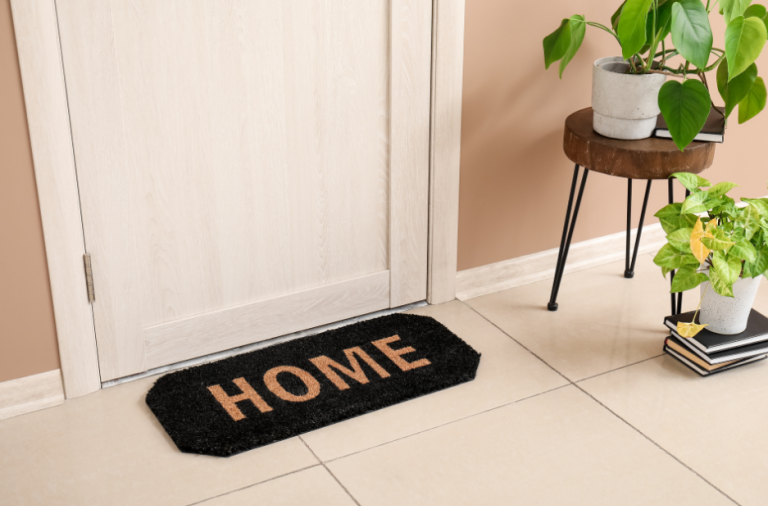 Front door with welcome mat saying 'home'