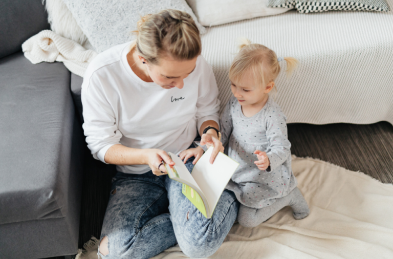Mother and daughter sat reading a book