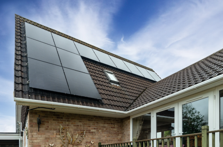 Solar panels installed on a modern home roof under a clear blue sky