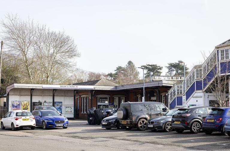 The main entrance to Twyford station on a sunny day, with lots of cars parked in front