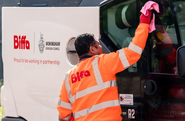 Crew member cleaning street cleansing vehicle as part of the council's waste and recycling service.