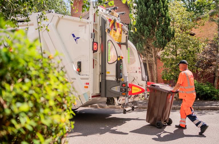 Waste collection crew working beside a collection vehicle during a household waste and recycling collection round in Wokingham Borough.