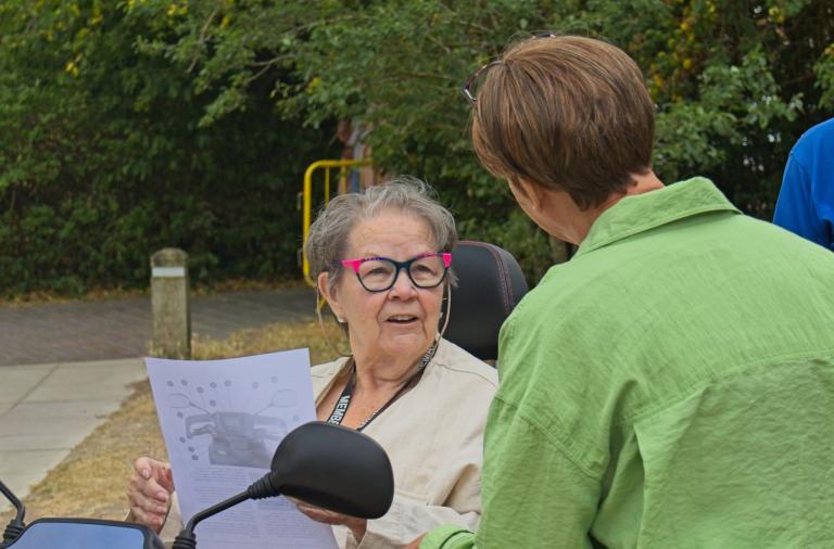 Person using a mobility scooter receives guidance before exploring Dinton Pastures.