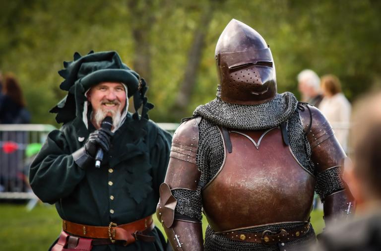 Two men dressed in medieval attire including a knight outfit