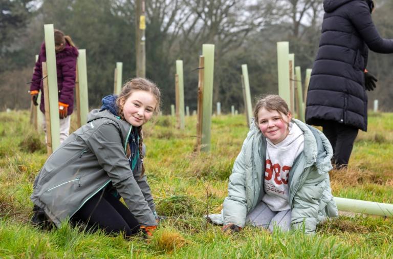 Schoolchildren planting young trees at the memorial woodland site.