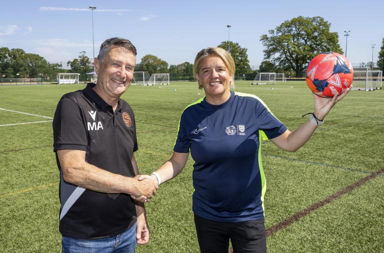 Mark Ashwell and Liz Verrall shaking hands on the 3G football pitch at Cantley Park