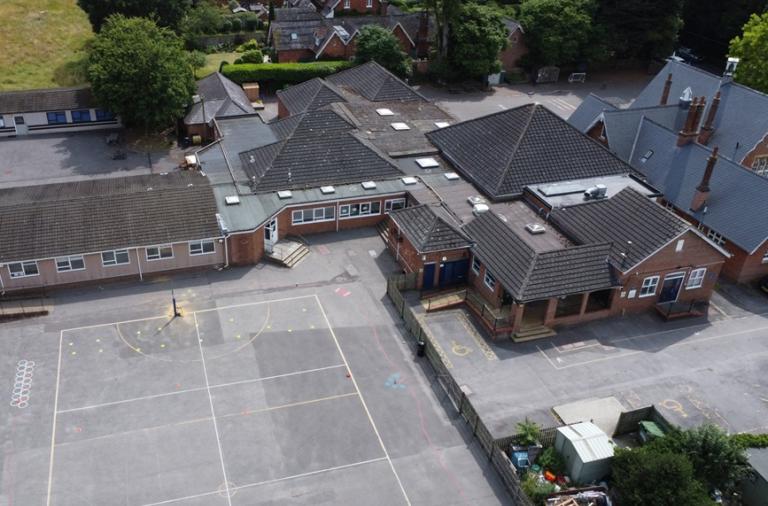 Aerial photo of the existing Bearwood Primary School site, with the playground and modern buildings behind an older red brick one
