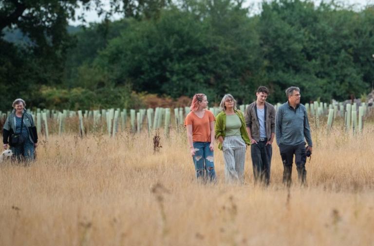 Visitors walk through the Covid Memorial Woodland during the opening event.