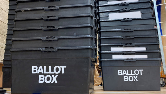 A stack of ballot boxes on the floor