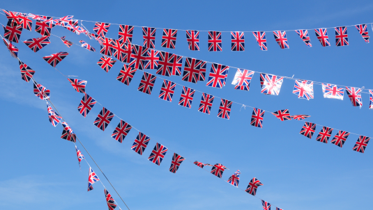 Union flag bunting joined together in front of a bright blue sky