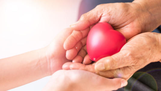 A heart shape inside two clasped set of hands