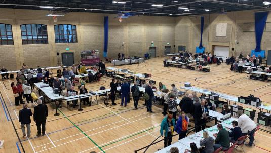 Colleagues count ballots at the local election count at Loddon Valley Leisure Centre